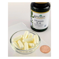 Thumbnail for A small glass bowl with white capsules is next to a bottle of Swanson Vitamin B6 Pyridoxine 100 mg 100 Capsules, highlighting its importance for energy metabolism and cardiovascular health, with a penny for scale.