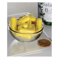 Thumbnail for A small glass bowl containing Swanson Balance Vitamin B-50 Complex capsules is next to a coin for size reference, with the bottle partially visible in the background.