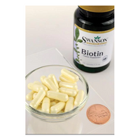 Thumbnail for A bottle of Swanson Biotin 5000 mcg 100 Capsules sits beside a bowl, with a penny for scale. This Vitamin B7 powerhouse supports healthy hair, skin, and nails, making it essential for your daily regimen.