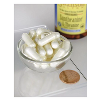 Thumbnail for A glass bowl of Swanson Suntheanine L-Theanine 100 mg veggie capsules is placed beside a penny for scale, suggesting their compact power. In the background, a partially visible bottle indicates these capsules promote relaxation and contain L-theanine, found in green tea.