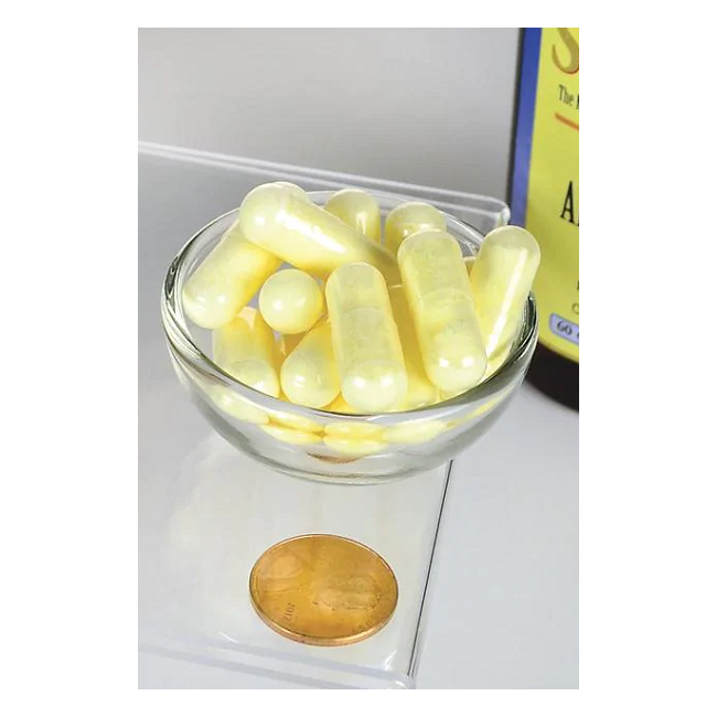 A small glass bowl with yellow capsules is on a scale for metabolic support, with a coin for size reference. In the background, a Swanson Alpha Lipoic Acid - 600 mg bottle is partly visible.