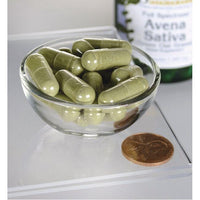 Miniatura per Una ciotola di Swanson Avena Sativa - 400 mg 60 capsule accanto a una bottiglia di olio d'oliva.