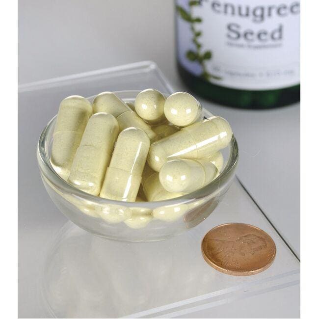 Un flacone di Swanson Fenugreek Seed - 610 mg 90 capsule è accanto a una ciotola di capsule.