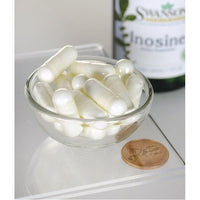 Miniatura per Una ciotola di pillole bianche accanto a un flacone di Swanson Inosina - 500 mg 60 capsule vegetali.