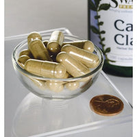 Miniatura per Artiglio di gatto - 500 mg 100 capsule in una ciotola accanto a una bottiglia di Swanson.