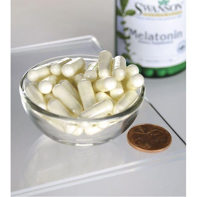 Swanson Melatonina - 1 mg 120 capsule in una ciotola accanto a una bottiglia di Swanson Melatonin.