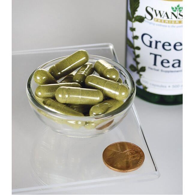 Una bottiglia di Tè verde Swanson - 500 mg 100 capsule con un centesimo accanto.