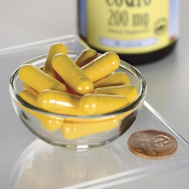Swanson Coenzima Q10 - 200 mg 90 capsule in una ciotola accanto a un penny.