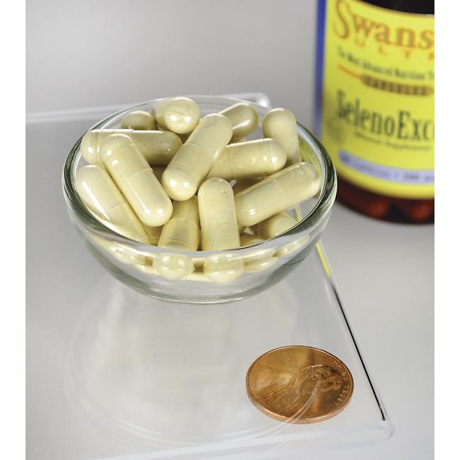 Un flacone di Swanson's SelenoExcell Selenium - 200 mcg 60 capsule integratori e un centesimo accanto a una ciotola di pillole, promuovendo la cura cardiovascolare.