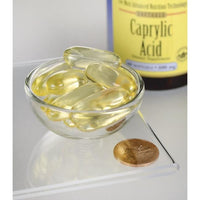 Miniatura per Swanson'Acido caprilico - 600 mg 60 capsule softgel integratore alimentare in una ciotola accanto a una moneta.