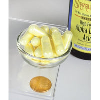Miniatura di un flacone di Acido alfa lipoico Swanson - 600 mg 60 capsule con accanto una moneta.