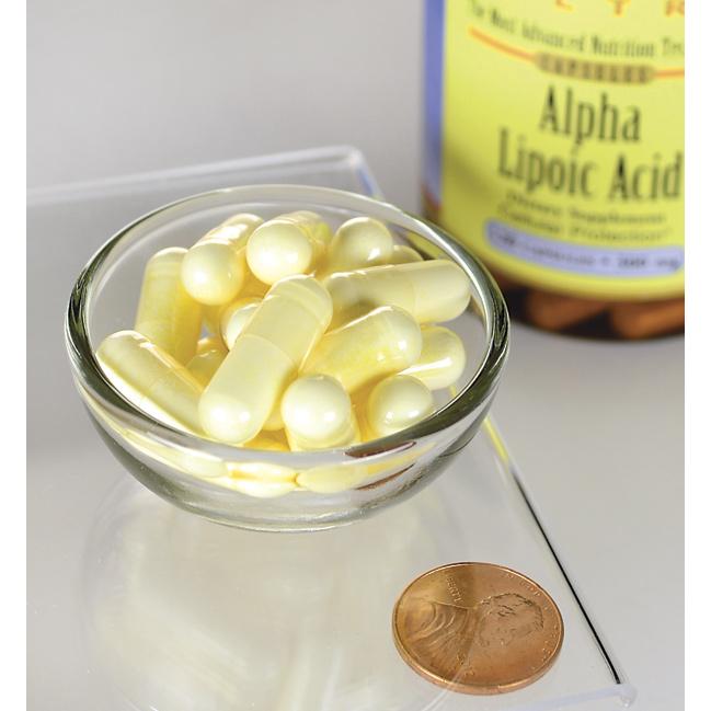 Un flacone di Acido alfa lipoico Swanson - 300 mg 120 capsule si trova accanto a un centesimo.